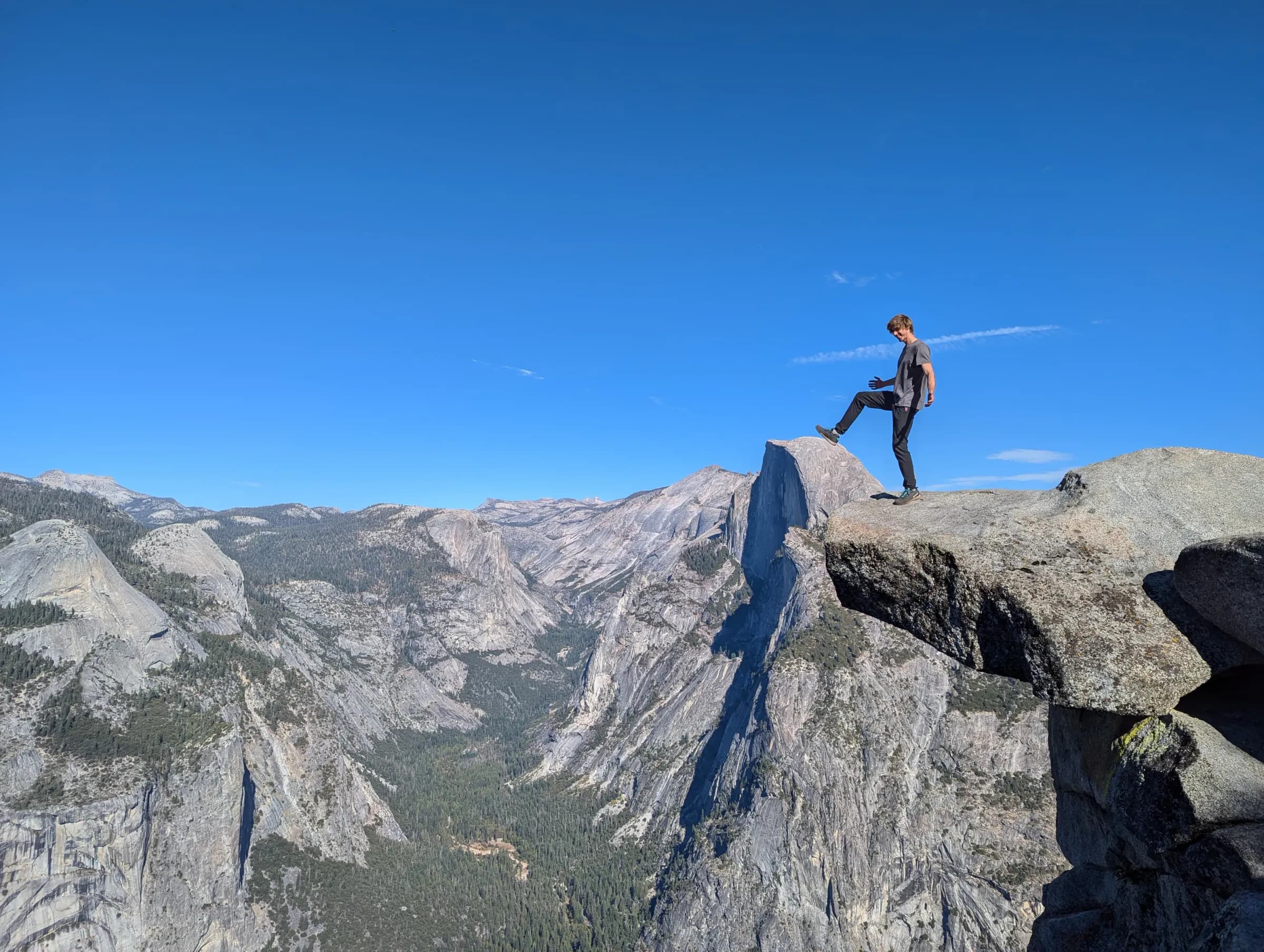 Wspinacz na skalnym występie Half Dome nad doliną Yosemite